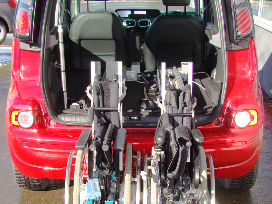 Zwei Rollstühle mit dem Rollstuhllift LADEBOY S stehend im Kofferraum verladen.
